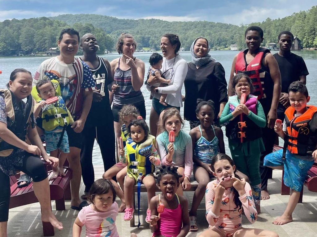 A group of Embrace families pose for a photo on a lake dock.