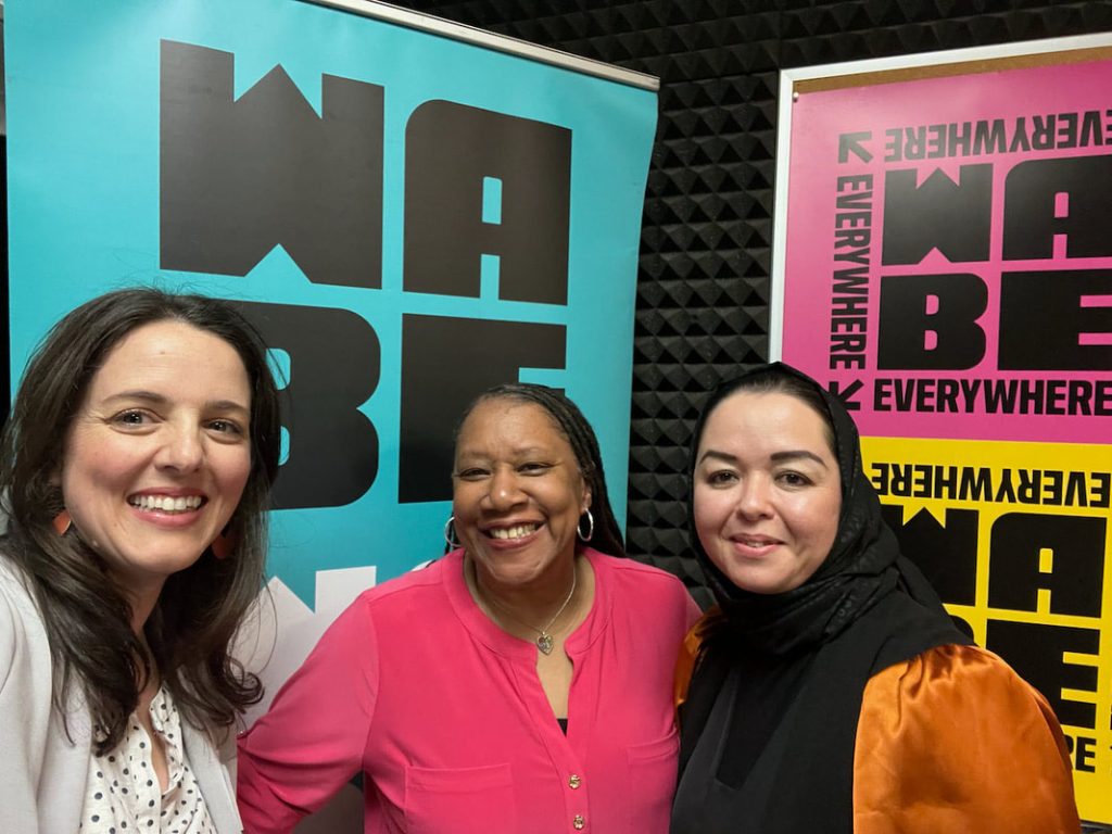 Three women pose for a photo at WABE's radio station.