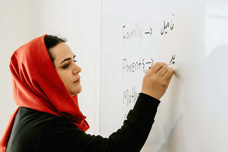 A woman writes on a whiteboard.