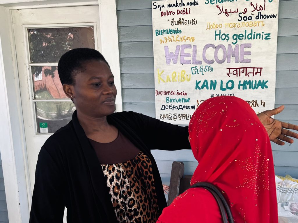 Two women hug on the porch of the Embrace office.