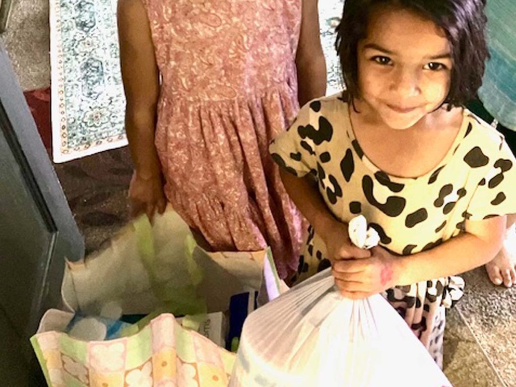 A young girl holds a gift bag.