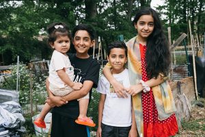 Four refugee children pose for a photo in the Jolly Ave. Garden