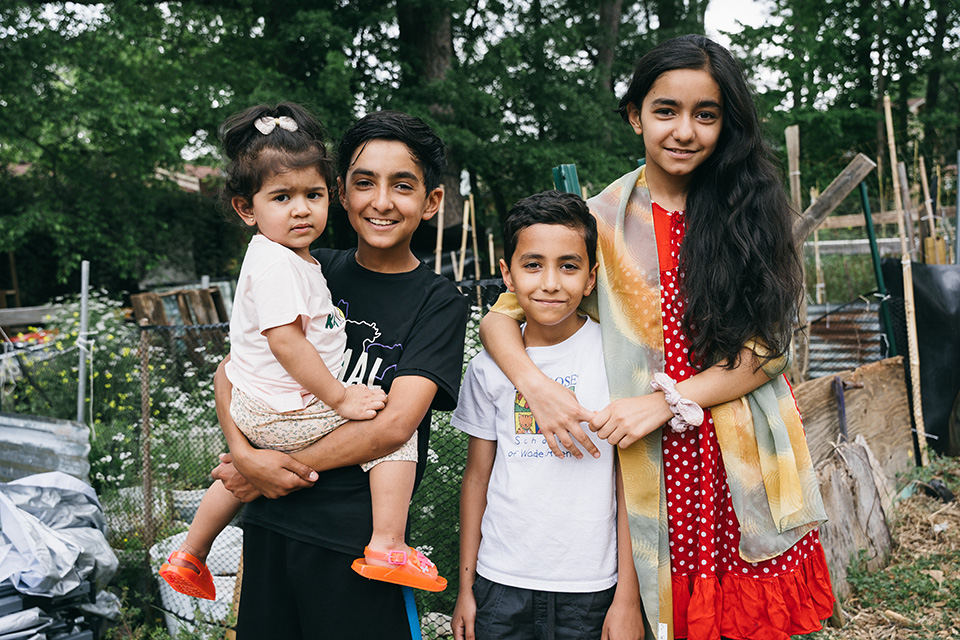 Four refugee children pose for a photo in the Jolly Ave. Garden