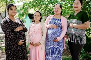 Four pregnant mothers pose for a photo.
