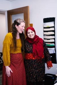 Two women laugh together in an office.