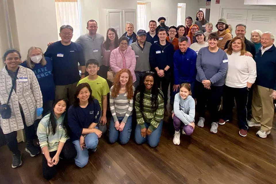 A group of volunteers pose for a photo inside of a house.