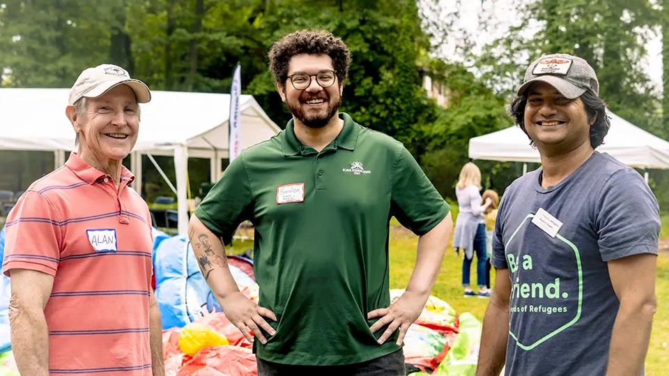 Three volunteers pose for a photo at Friends of Refugee's Spring Festival.