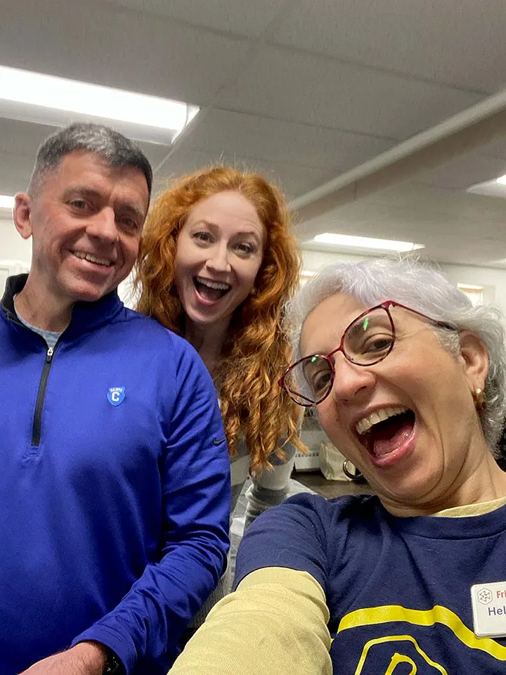 Three volunteers pose for a selfie.