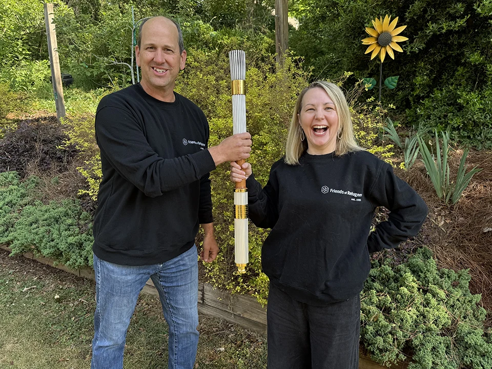 Kevin Kipfer and Kendra Jefferys hold an Olympic torch at the Jolly Avenue Garden.